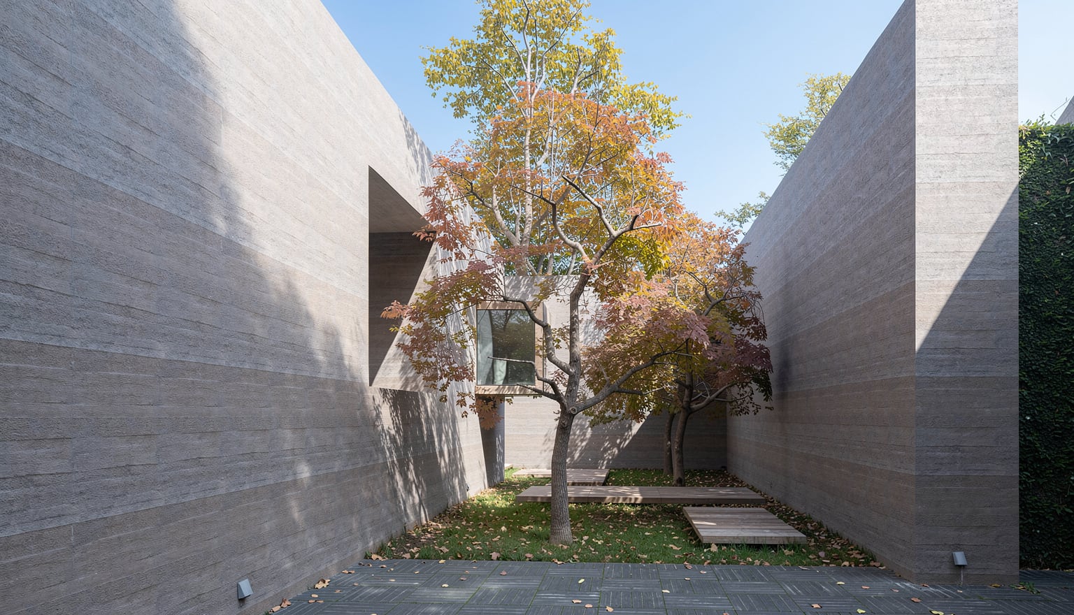 Courtyard path enclosed by tactile earthen walls